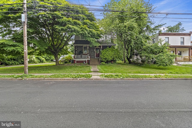 view of front of property with covered porch and a front yard