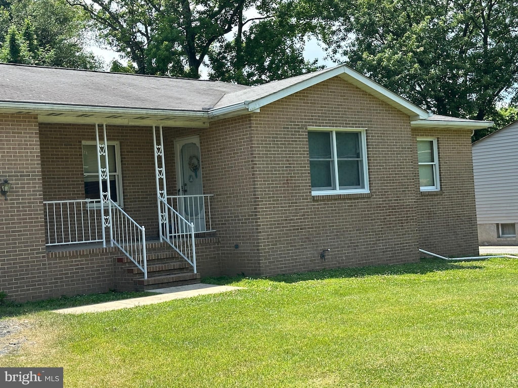 view of front of property with a porch and a front lawn