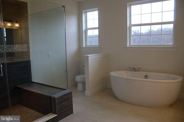 bathroom with toilet, separate shower and tub, and a wealth of natural light