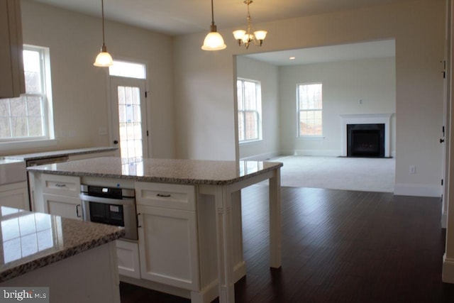 kitchen featuring white cabinetry, stainless steel oven, and decorative light fixtures