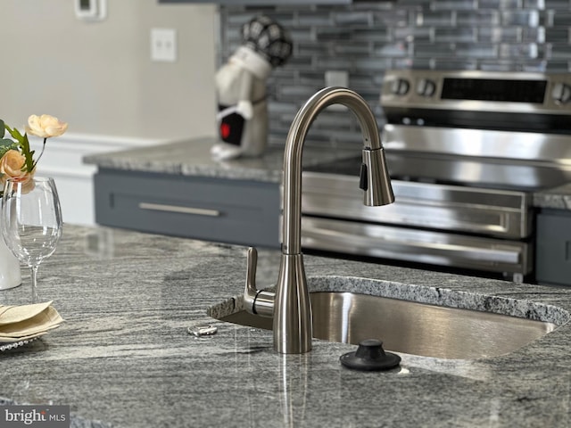 interior details with dark stone countertops, sink, and tasteful backsplash