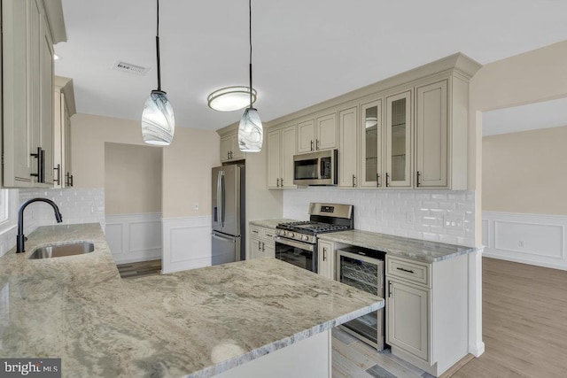 kitchen featuring tasteful backsplash, stainless steel appliances, hanging light fixtures, and sink