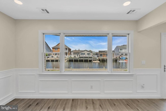 unfurnished dining area featuring a water view and hardwood / wood-style flooring