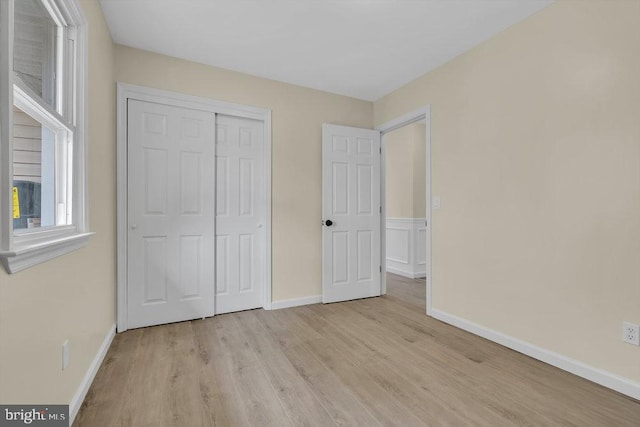 unfurnished bedroom featuring light hardwood / wood-style floors and a closet