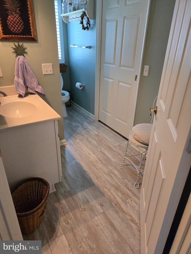 bathroom featuring vanity, toilet, and wood-type flooring