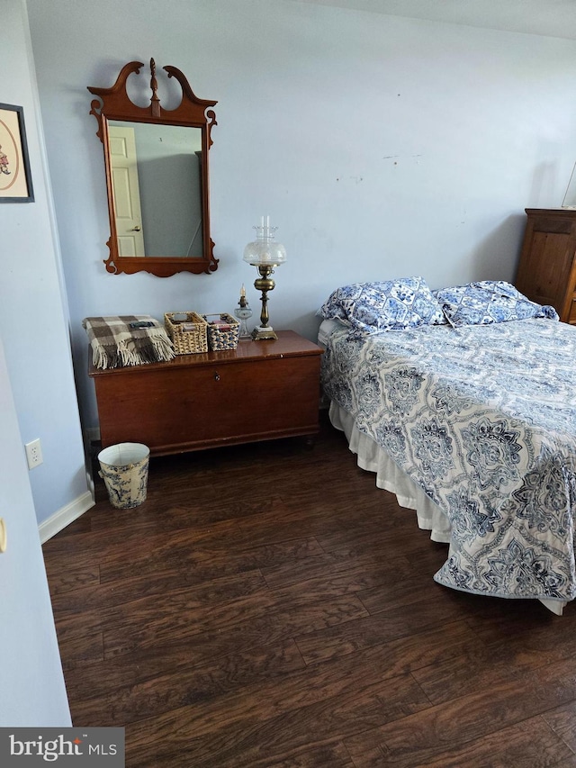 bedroom with dark hardwood / wood-style floors