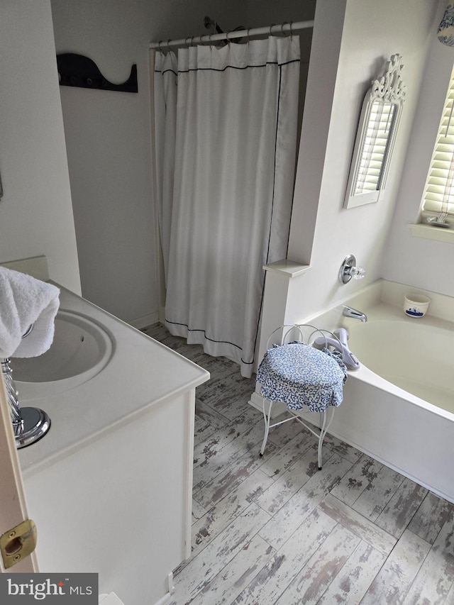 bathroom featuring a washtub and vanity