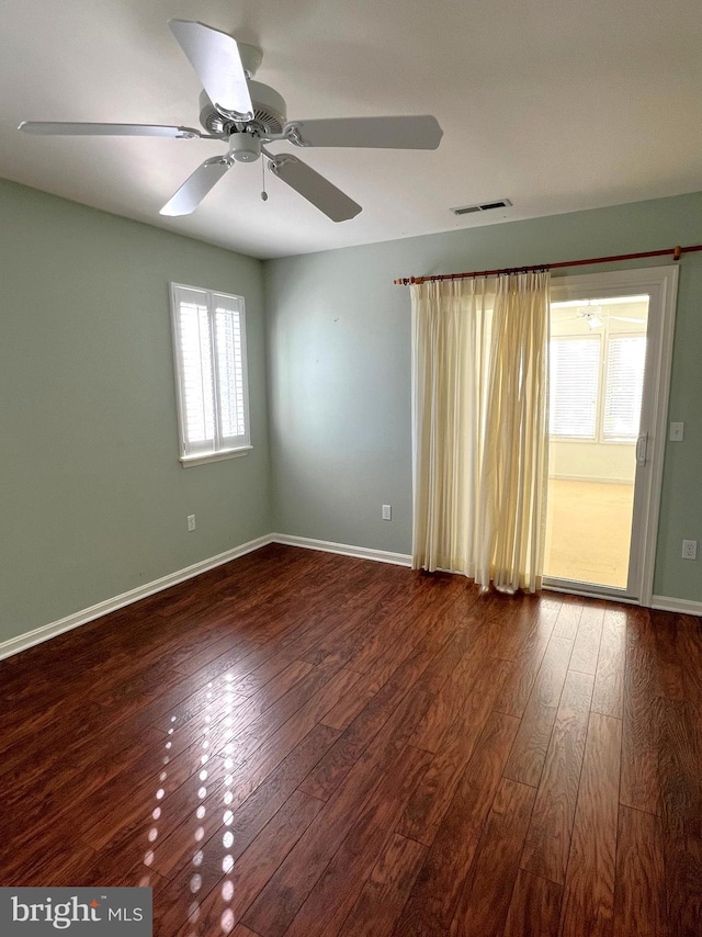 unfurnished room featuring ceiling fan and dark wood-type flooring