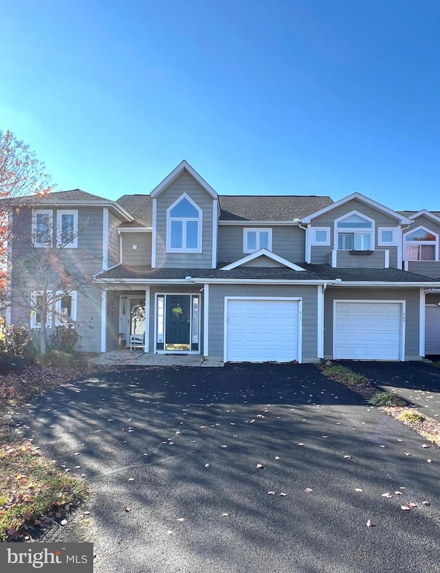 multi unit property featuring covered porch and a garage