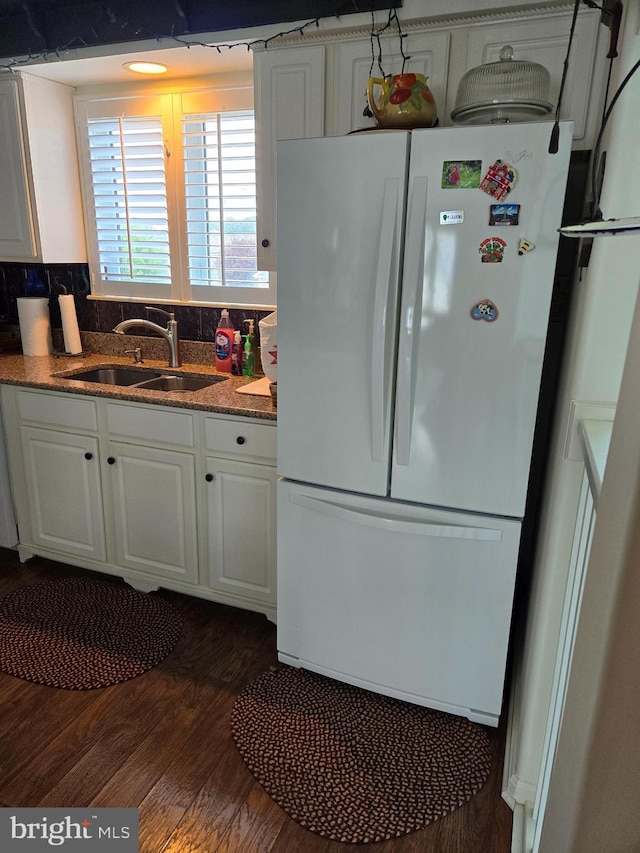 kitchen featuring backsplash, sink, white refrigerator, dark hardwood / wood-style floors, and white cabinetry