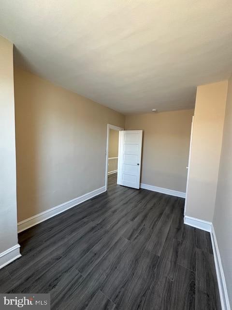 unfurnished room featuring dark wood-type flooring