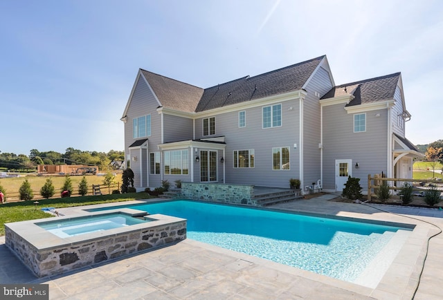 rear view of house featuring a swimming pool with hot tub