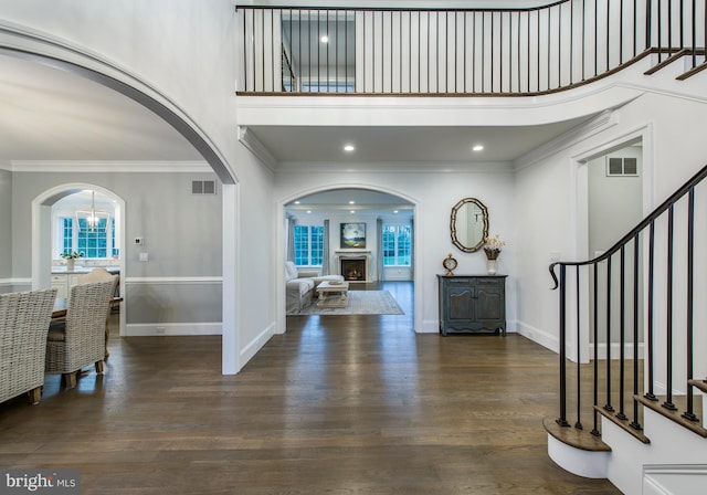 entrance foyer with crown molding, a high ceiling, and dark hardwood / wood-style floors