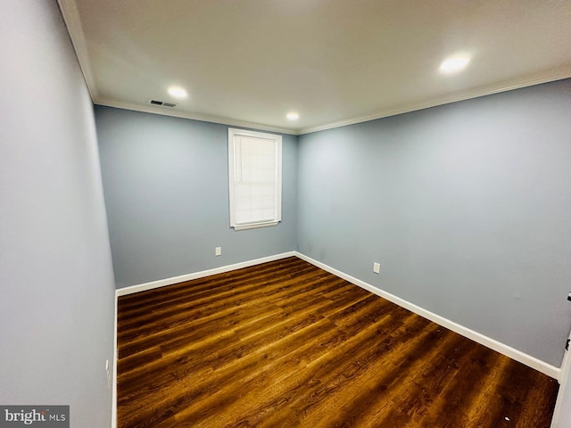 empty room with dark hardwood / wood-style flooring and crown molding