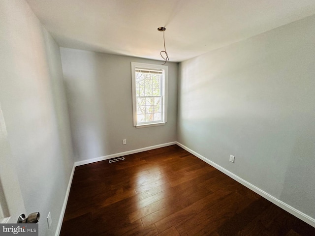 unfurnished room with dark wood-type flooring