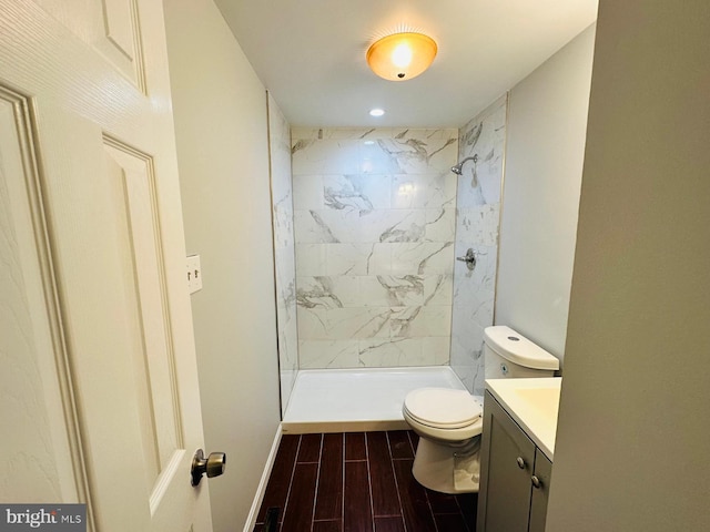 bathroom with vanity, toilet, and tiled shower