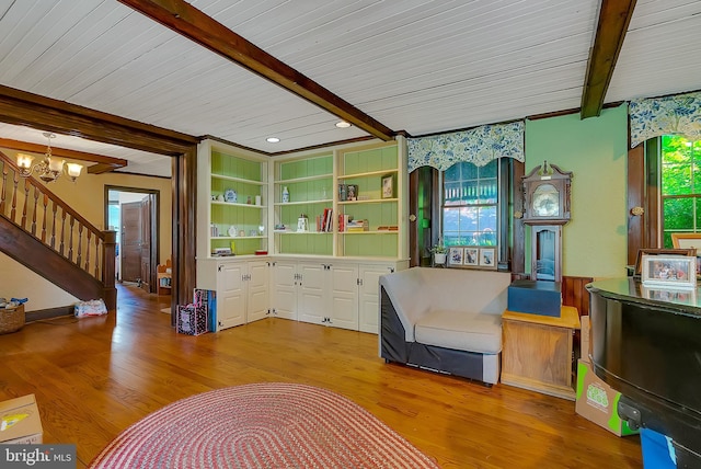 sitting room with a chandelier, beam ceiling, and light hardwood / wood-style floors