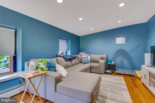 living room featuring baseboard heating and light hardwood / wood-style flooring