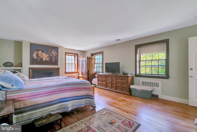 bedroom with light hardwood / wood-style floors and radiator