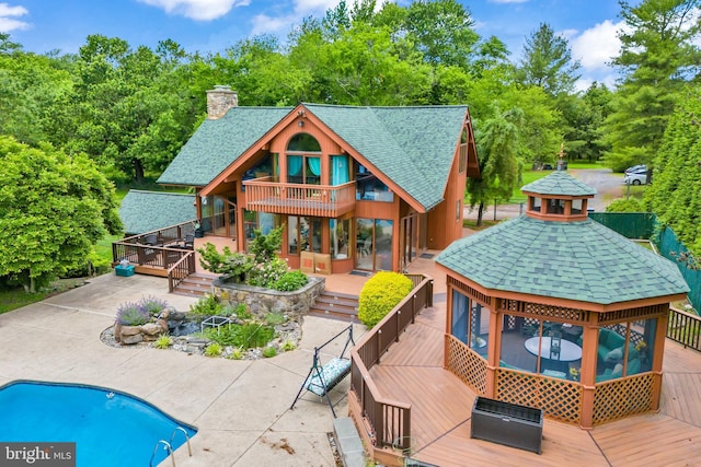 rear view of house featuring a gazebo, a patio area, and a pool side deck