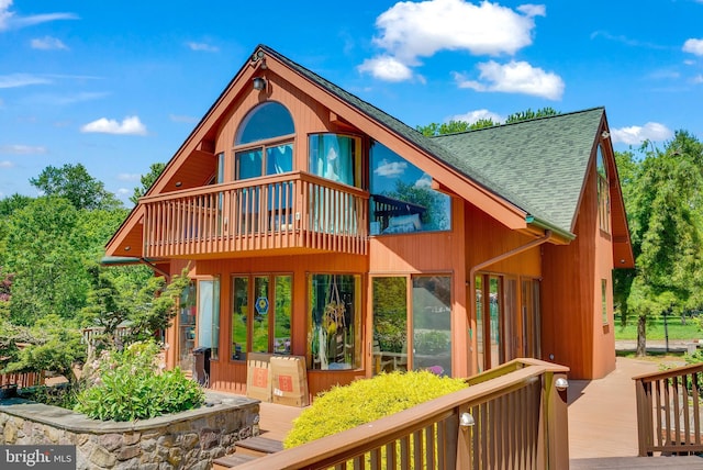 rear view of house featuring a wooden deck