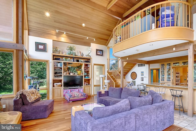 living room featuring beamed ceiling, light wood-type flooring, wooden ceiling, and high vaulted ceiling