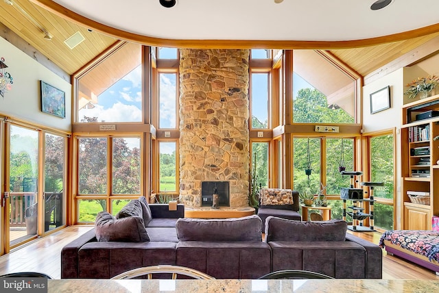 living room with light hardwood / wood-style flooring, high vaulted ceiling, and wooden ceiling