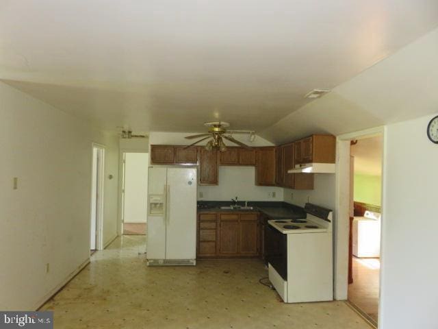 kitchen with white appliances, vaulted ceiling, ceiling fan, sink, and washer / clothes dryer