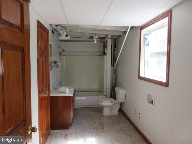 full bathroom with vanity, shower / tub combination, a paneled ceiling, and toilet