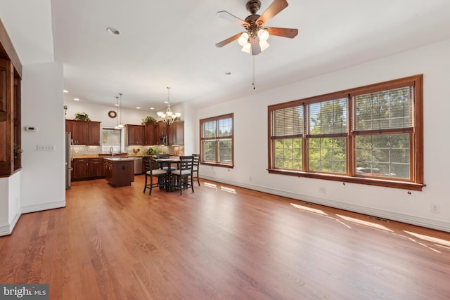 interior space with hardwood / wood-style flooring, ceiling fan with notable chandelier, and sink