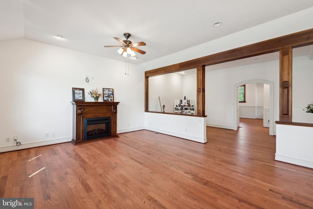 unfurnished living room featuring hardwood / wood-style flooring, vaulted ceiling, and ceiling fan