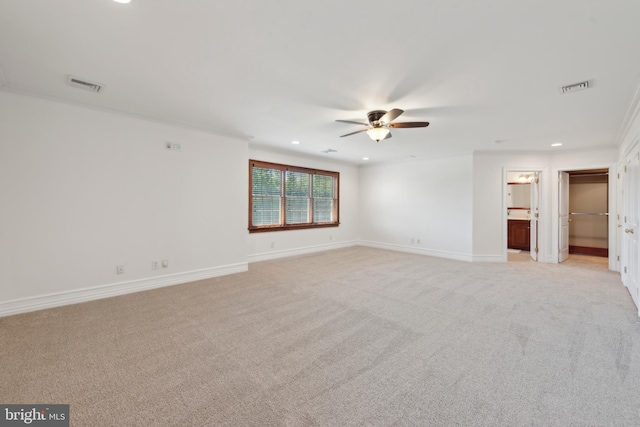 carpeted spare room featuring ceiling fan and ornamental molding