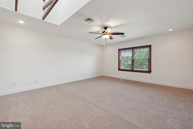 carpeted spare room with a skylight and ceiling fan