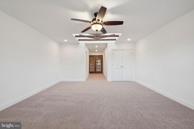 empty room featuring ceiling fan, french doors, and light colored carpet