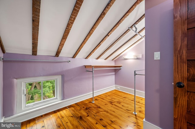 additional living space featuring lofted ceiling with beams and wood-type flooring