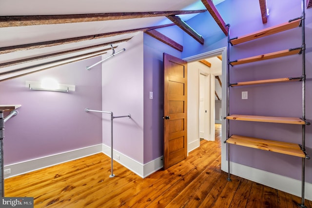 interior space with lofted ceiling with beams and wood-type flooring