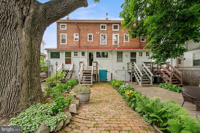 back of house with a patio area and a wooden deck