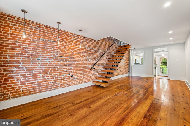 interior space with hardwood / wood-style flooring and brick wall