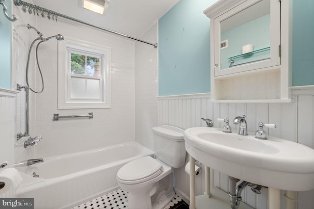 full bathroom with tile patterned flooring, tiled shower / bath combo, toilet, and sink