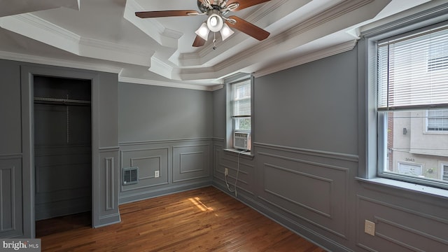 unfurnished bedroom with dark wood-type flooring, multiple windows, crown molding, and ceiling fan