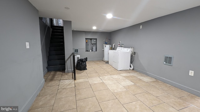 washroom featuring separate washer and dryer, water heater, and light tile patterned floors