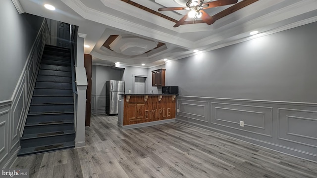 kitchen with a breakfast bar, crown molding, and stainless steel refrigerator