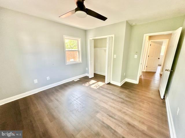 unfurnished bedroom featuring hardwood / wood-style floors, ceiling fan, and a closet