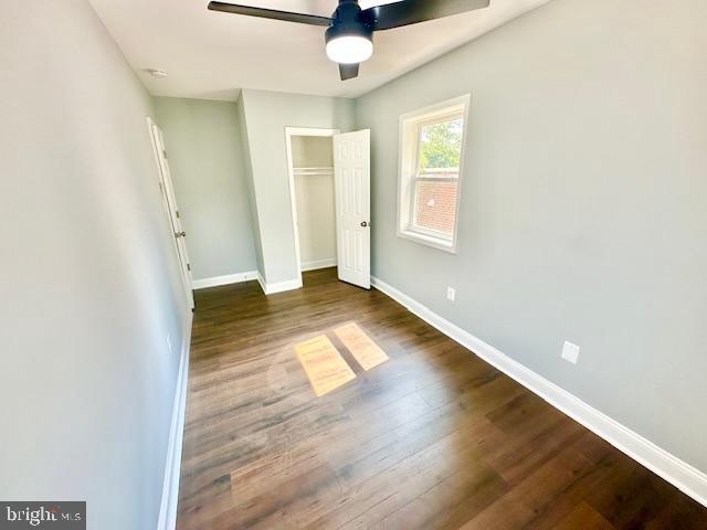 unfurnished bedroom with ceiling fan and dark hardwood / wood-style flooring