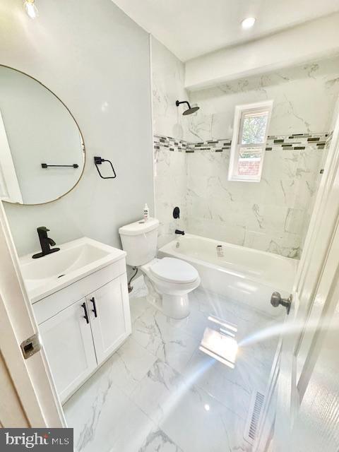 full bathroom featuring vanity, toilet, and tiled shower / bath