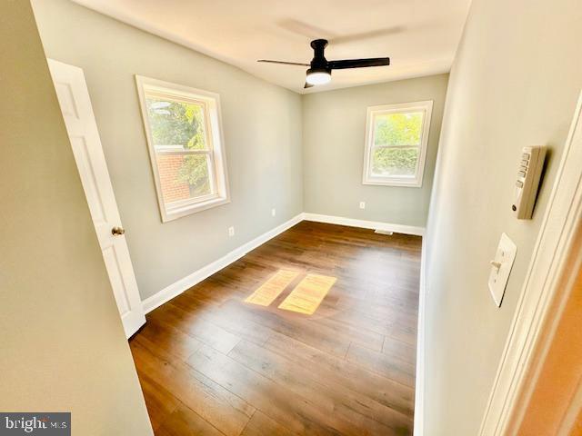 spare room featuring ceiling fan and dark hardwood / wood-style flooring