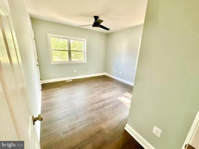 empty room featuring dark hardwood / wood-style floors and ceiling fan