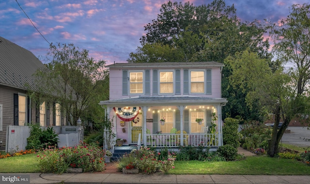 view of front of home with a porch and a lawn