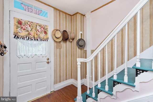 foyer with ornamental molding and hardwood / wood-style floors