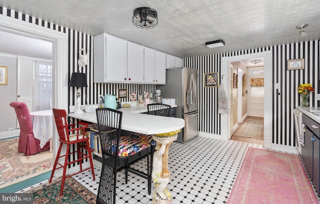 kitchen featuring light tile patterned floors, white cabinetry, and stainless steel fridge with ice dispenser